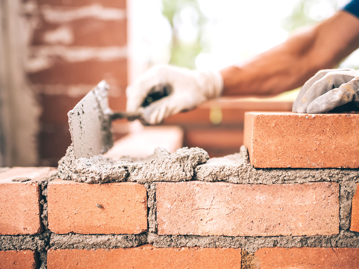 Bricklayer working on building a basement wall.